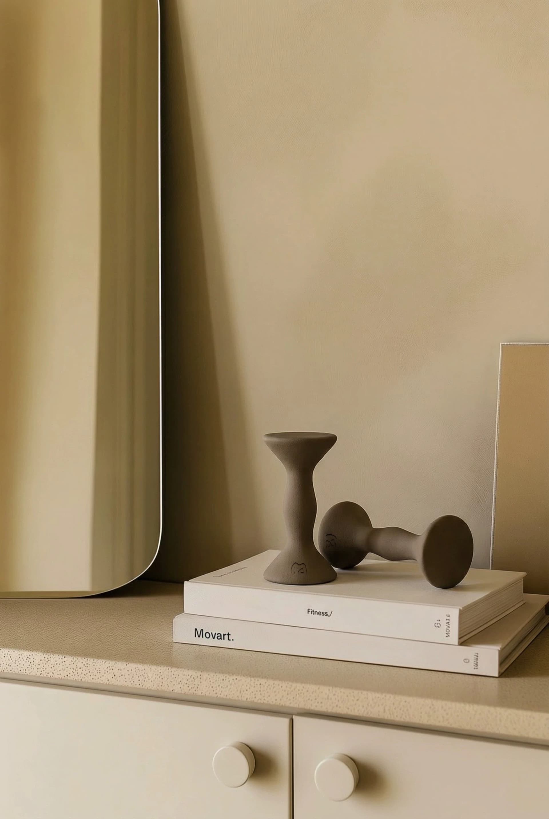 MOVART dumbbell and sculptural weight on stacked books